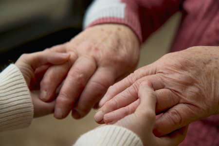 The hands of a young girl hold the bitches of her elderly grandmother. The concept of love and care for the elderly, respect within the family and acceptance of old age.の写真素材