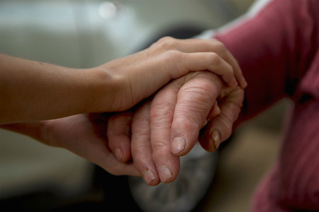 The hands of a young girl hold the bitches of her elderly grandmother. The concept of love and care for the elderly, respect within the family and acceptance of old age.の写真素材