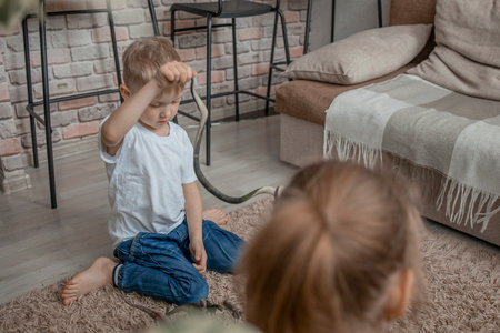 The younger brother and sister play with plastic animals and a rubber toy snake. Development of communication through childrens games. Friendship and cheerful mood.の写真素材
