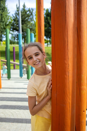 portrait of a smiling cute blonde teenage girl. A walk through the city park on a warm summer day.の写真素材