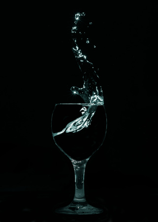 Splash of water from glass in thick smokeの写真素材