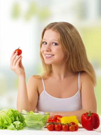 beautiful woman with vegetables in a kitchenの写真素材