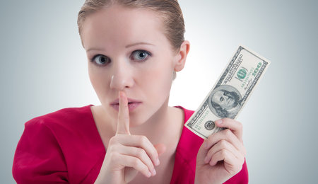 woman with money, dollars  raised her finger to her mouth and says 