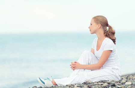 young woman in white relax resting on the sea on the beachの写真素材