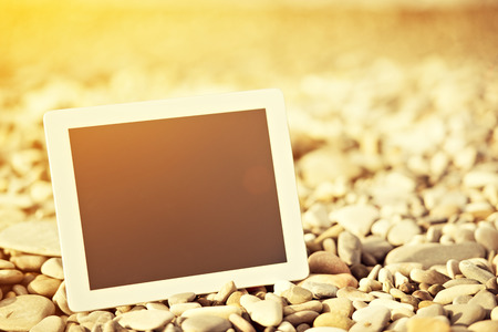 concept of internet and communication. blank empty tablet computer on the beachの写真素材
