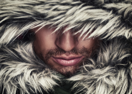 brutal face of a man with beard bristles and hooded winterの写真素材