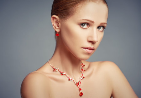 beauty girl with red jewelry necklace and earrings with rubiesの写真素材