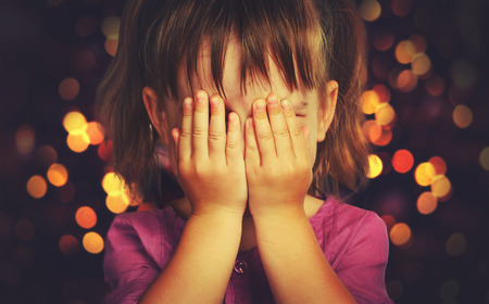 little girl closed eyes  her hands in anticipation of a Christmas miracle and a giftの写真素材