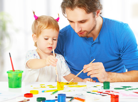 happy family father and child baby daughter together draw paintsの写真素材