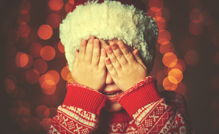 little girl closed eyes  her hands in anticipation of a Christmas miracle and a giftの写真素材