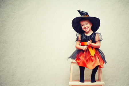 Halloween. cheerful little witch with a magic wand conjure and laughs.の写真素材