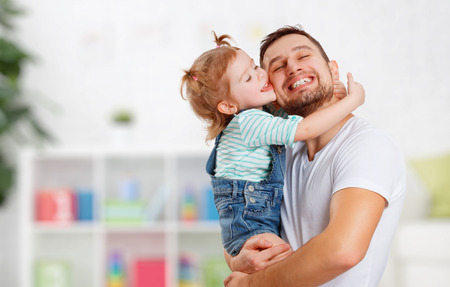 happy family and father's day. child daughter kissing and hugging dad happy family and father's day. child daughter kissing and hugging dad