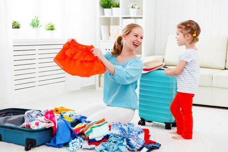 happy family tourist mother and child daughter suitcases packed for vacationの写真素材