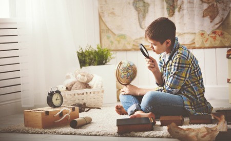 child boy teenager studying a map of the world, globe, geography, dreams of travelの写真素材