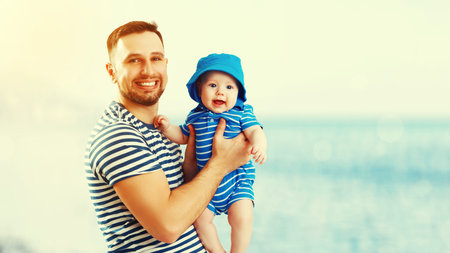 happy family father and baby son on the beach by the sea at sunset