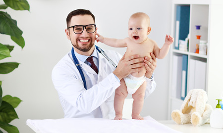 Doctor pediatrician with baby child in clinicの写真素材