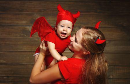 Family fun mother and baby son having fun and celebrate Halloween in devil costumeの写真素材