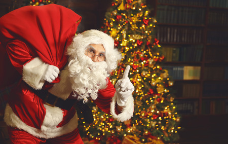 Portrait of Santa Claus with gifts around Christmas treeの写真素材