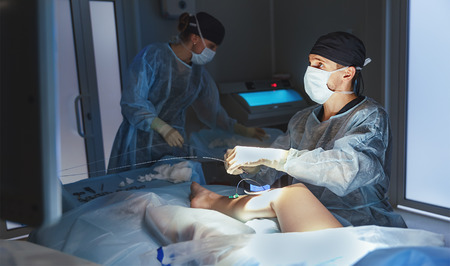 doctor and an assistant in the operating room for surgical venous vascular surgery clinicの写真素材
