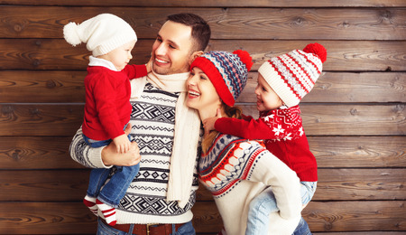 happy family mother, father and children  in winter hats on an empty wooden backgroundの写真素材