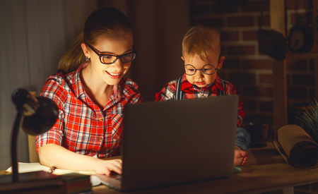 woman mother working  with a baby at home behind a computer via the Internetの写真素材