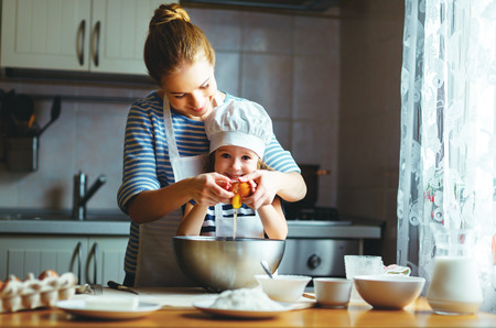 happy family in the kitchen. mother and  child daughter preparing the dough, bake cookies
の写真素材