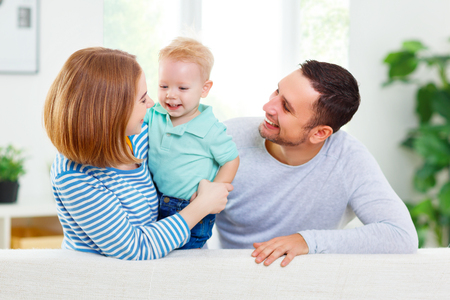 Happy family mother, father, child son at homeの写真素材