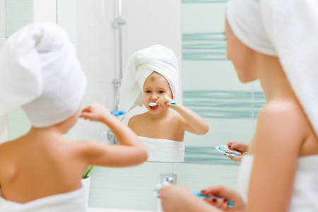 Mother and child daughter brush their teeth with a toothbrush in the bathroom
の写真素材