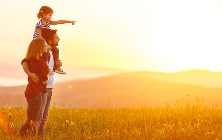 Happy family: mother father and child daughter on nature  on sunsetの写真素材