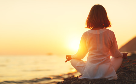 woman practices yoga and meditates in the lotus position on sunset beach
の写真素材