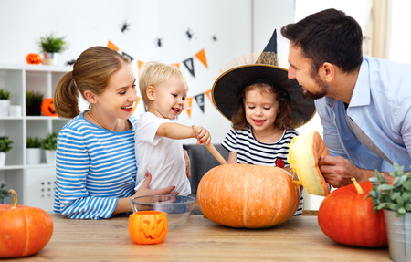 happy family mother father and children cut pumpkin for   holiday of halloweenの写真素材