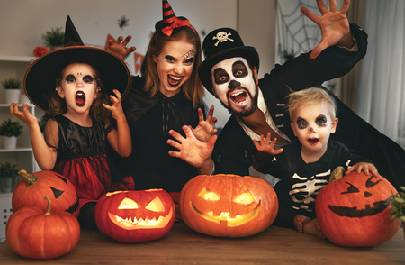 happy family mother father and children in costumes and makeup on a celebration of Halloween