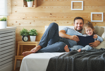 happy family father and child daughter reading book in bed
の写真素材