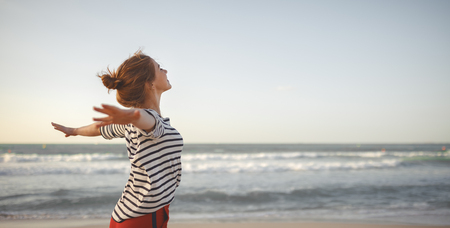 happy young woman enjoying freedom with open hands on sea
の写真素材