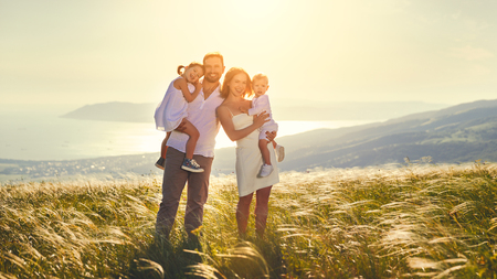 Happy family: mother, father, children son and  daughter on nature  on sunsetの写真素材