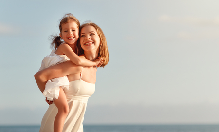 happy family at the beach. mother hugging child daughter 
の写真素材