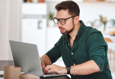 Happy man businessman, freelancer, student working at computer at home and officeの写真素材