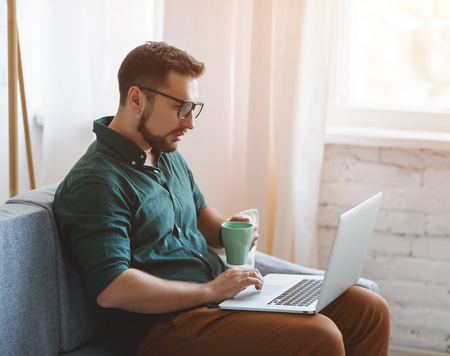 Happy man businessman, freelancer, student working at computer at home and office
の写真素材