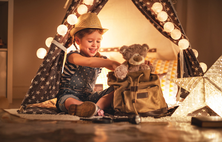 funny happy child girl tourist with flashlight and world map and backpack  
の写真素材