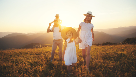 Happy family: mother, father, children son and  daughter on nature  on sunsetの写真素材