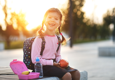 schoolgirl child eating lunch apples and bananas   at schoolの写真素材