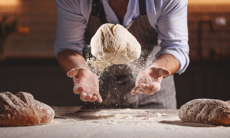 hands of the baker's male knead doughの写真素材