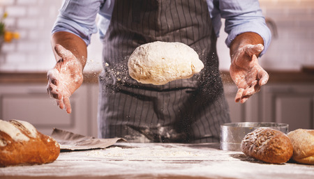 hands of the baker's male knead doughの写真素材