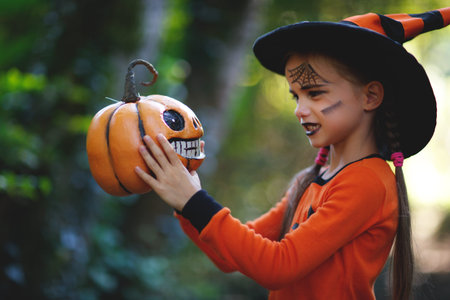 Happy Halloween! horrible creepy child girl in  pumpkin costume  in the forestの写真素材