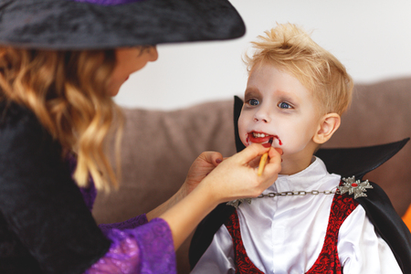 happy family mother and son getting ready for halloween make make-upの写真素材