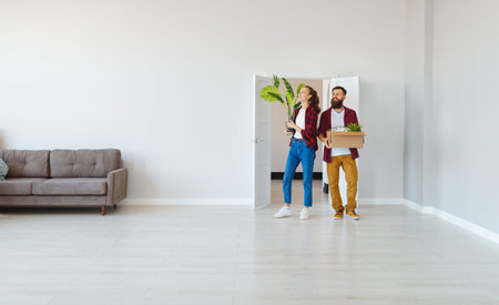 a happy young married couple moves to new apartment