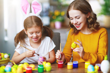 Happy Easter! family mother and child daughter with ears hare getting ready for holiday