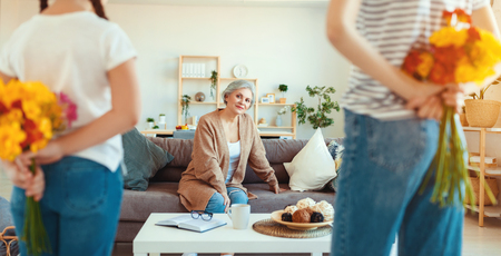 Mother's day! Three generations of a loving family mother, grandmother and daughter congratulate on the holiday, give flowersの写真素材