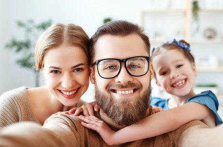 Cheerful happy family mother, father and child take selfies, take pictures at homeの写真素材