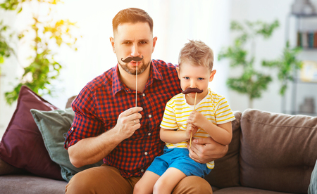 Father's day. Happy funny family son and dad with mustache on holiday.の写真素材
